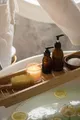 Angolo benessere con lavabo, candele accese, asciugamani e oggetti da cura del corpo, illuminato da luce calda.